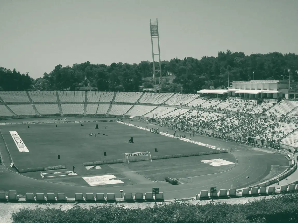 Estádio Nacional do Jamor visto do topo, com relvado dentro da pista e pinheiros à volta